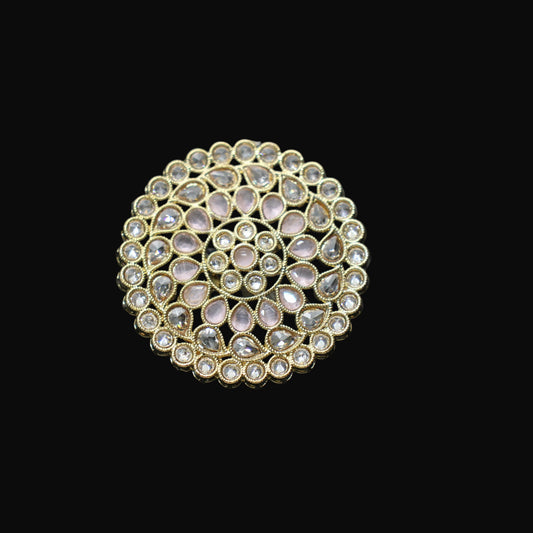 Gold ring with gemstones on a black mannequin hand against a dark background