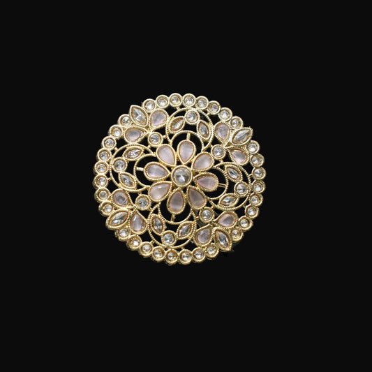 Gold ring with intricate design on a black mannequin hand against a dark background