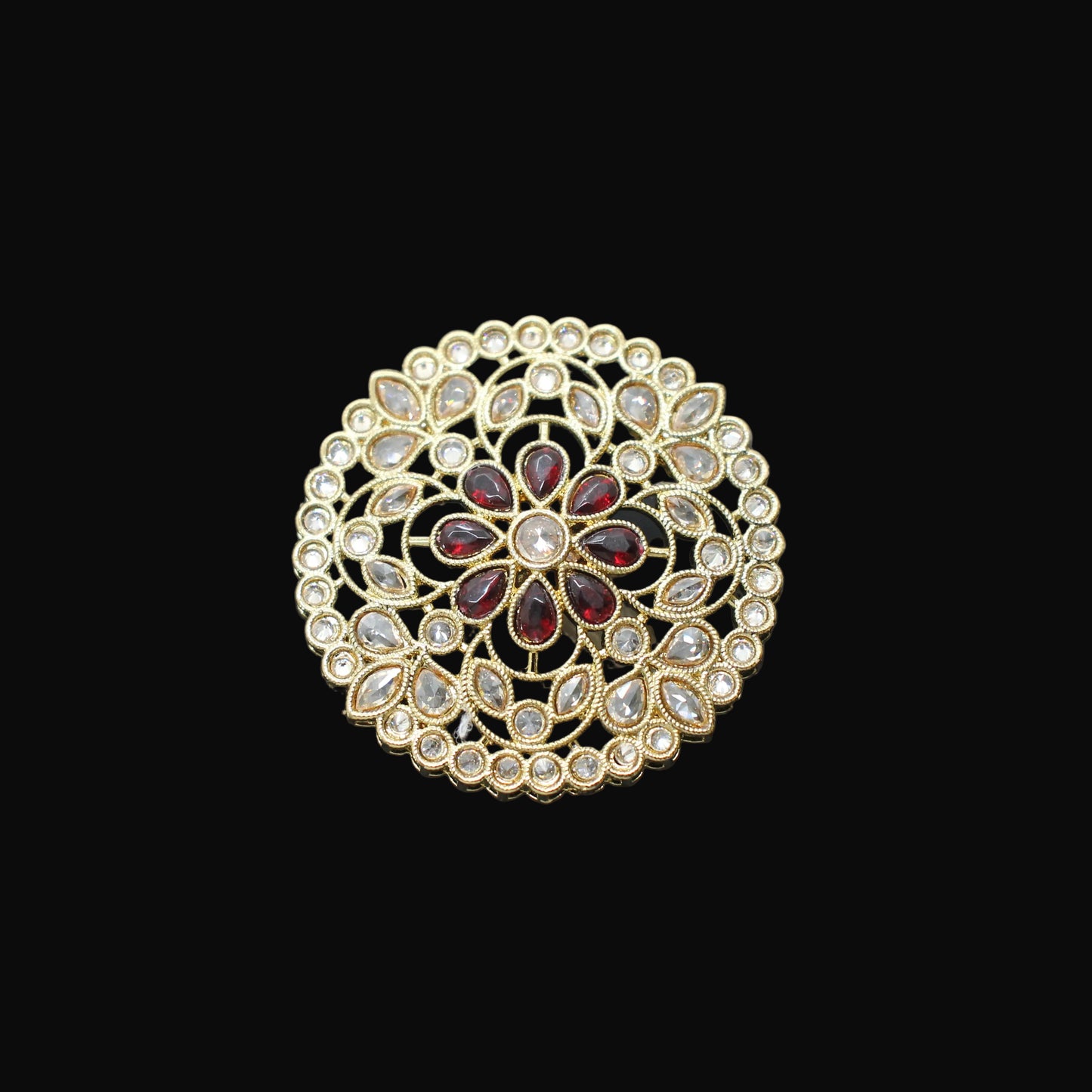 Gold and red gemstone ring on a black mannequin hand against a gray background