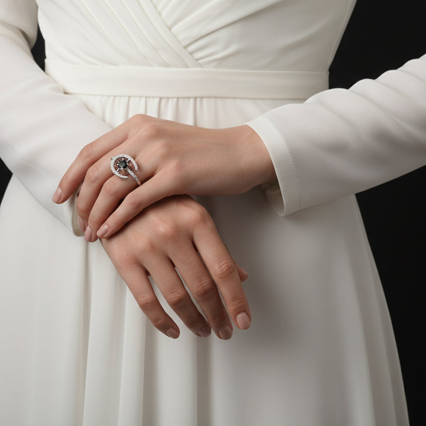 Silver ring with a star design on a black mannequin hand, branded 'Saheli'.
