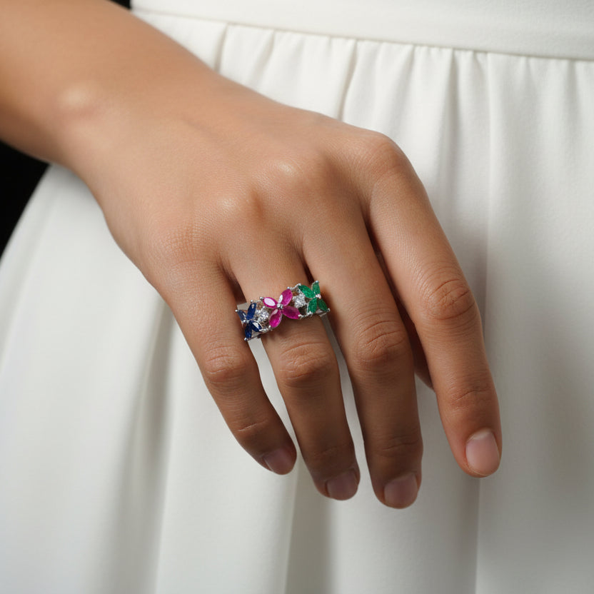 Colorful brooch on a black gloved hand with 'SAHELI' branding.