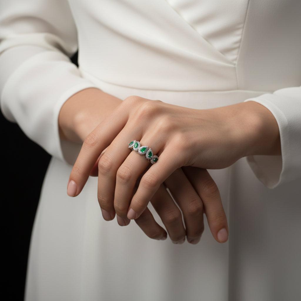 Silver ring with green gemstones on a gray background, featuring the brand 'SAHELL'.