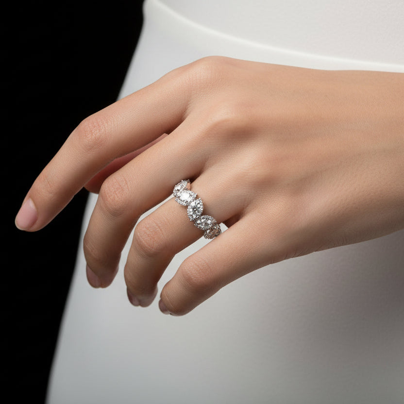 Silver ring with diamonds on a gray background, featuring the brand 'Saheili'.