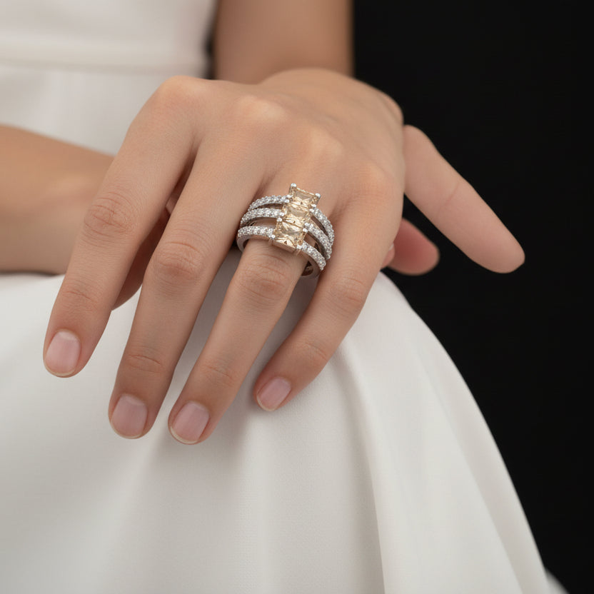 Silver ring with gemstones on a gray background, featuring the brand 'Saheli'.