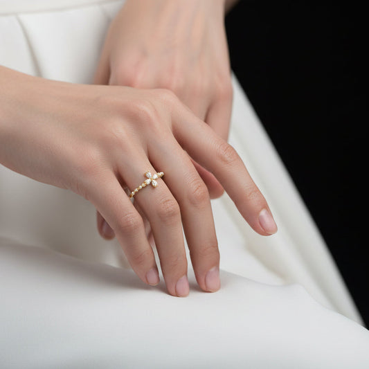 Gold cross ring on a black mannequin hand