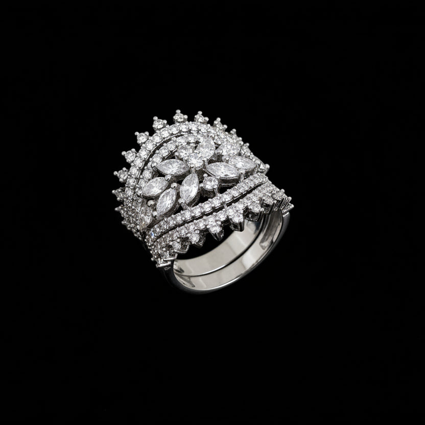 Silver ring with diamonds on a dark background, featuring the brand 'SAHELI'.