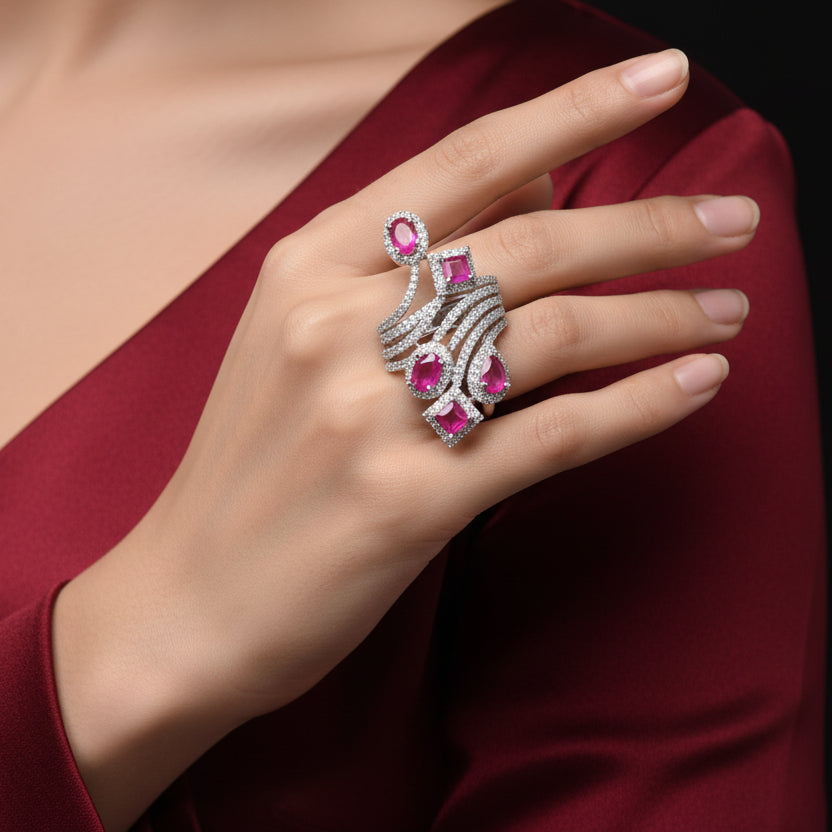 Jewelry with pink gemstones on a gray background, featuring the brand 'Saheli'.