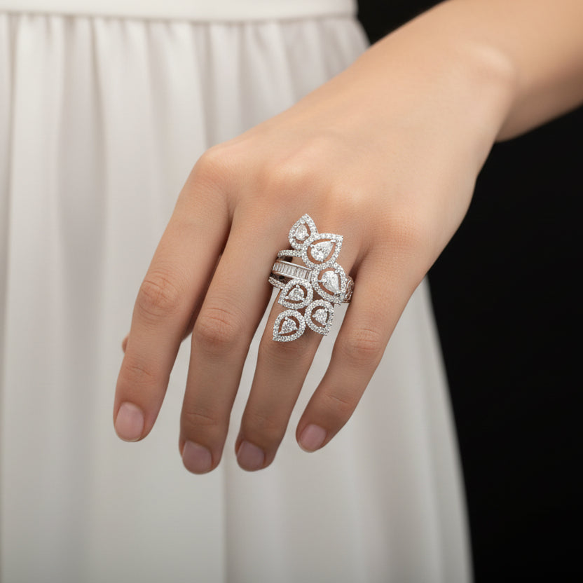 Silver ring with gemstones on a gray background, featuring the brand 'SAHELLI'.