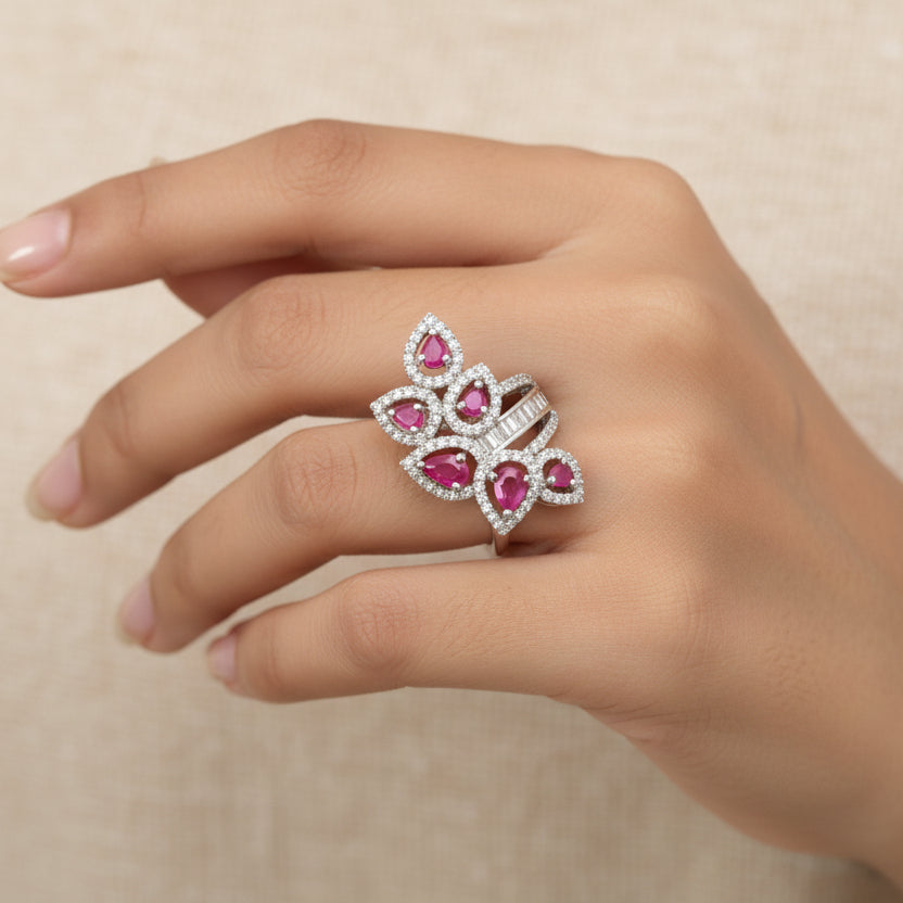 Silver ring with pink gemstones on a gray background, featuring the brand 'Saheli'.