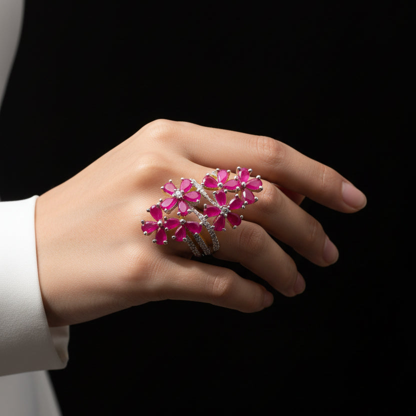 Jewelry with pink flowers on a gray background, featuring the brand 'Saheli'.