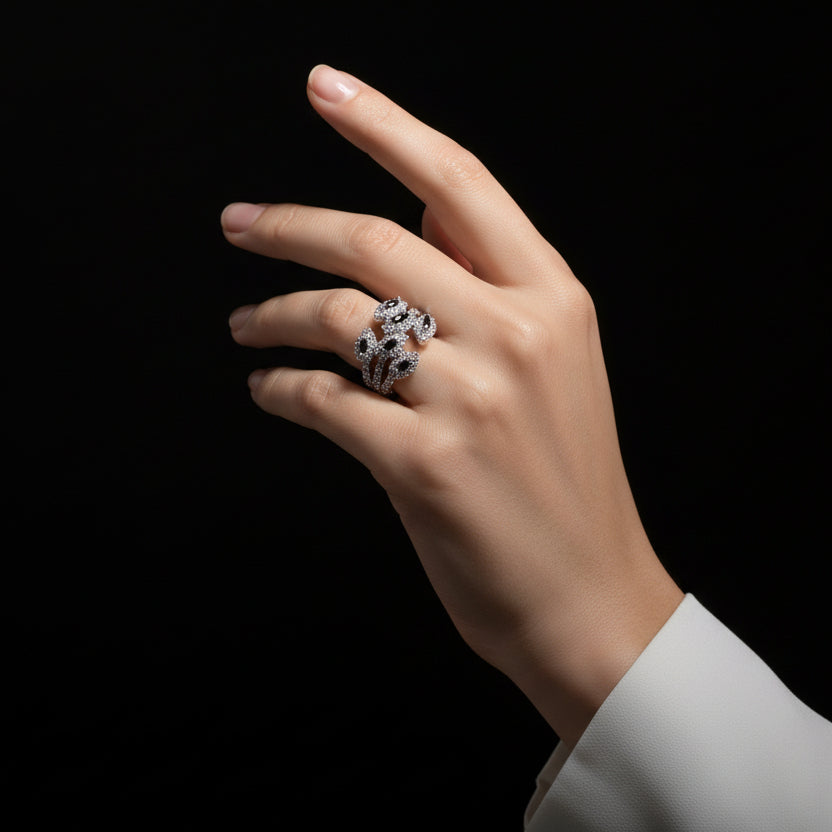 Silver ring with black stones on a gray background, featuring the brand 'SAHELI'.