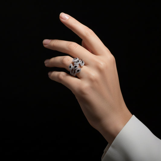 Silver ring with black stones on a gray background, featuring the brand 'SAHELI'.