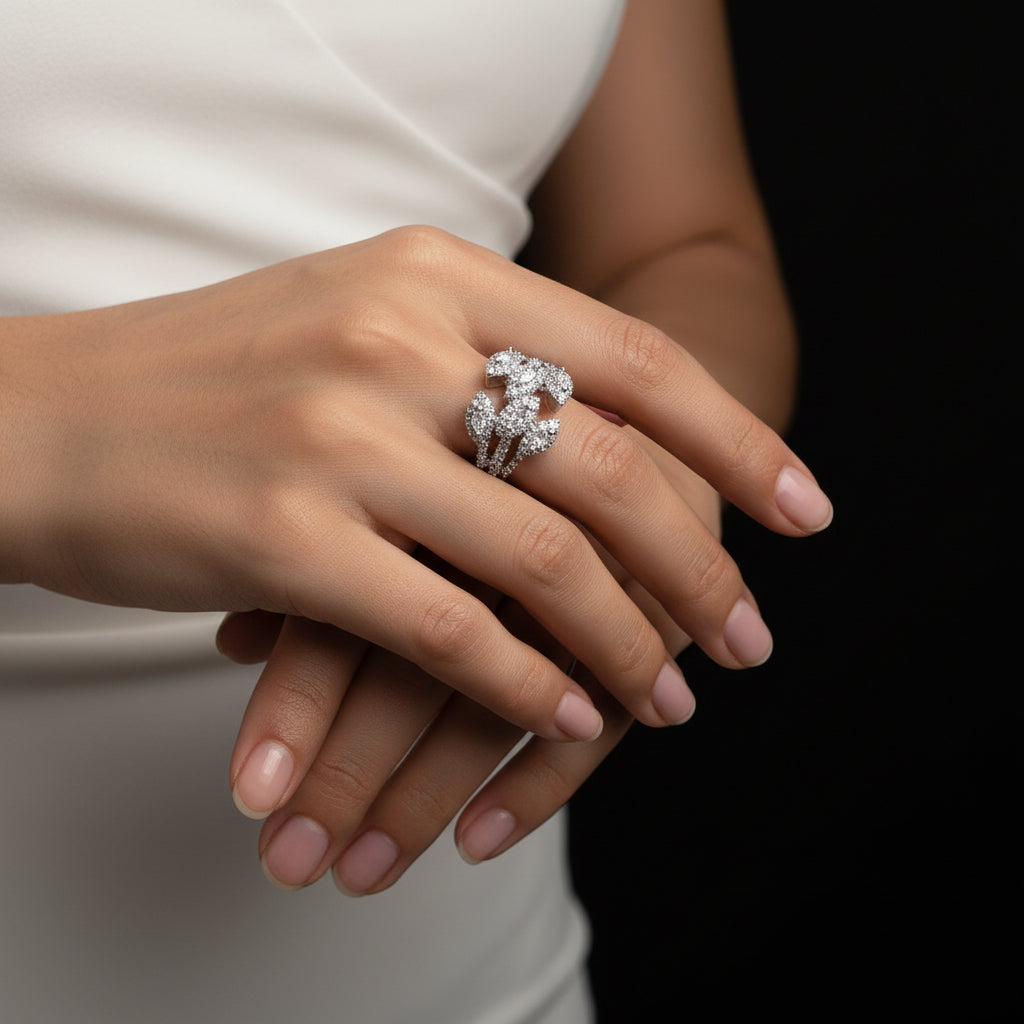 Silver ring with intricate design on a gray background, featuring the brand 'Saheli'.