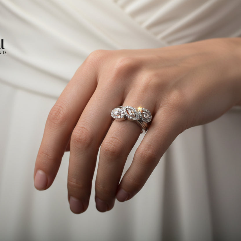 Silver ring with diamonds on a gray background, branded 'SAHELI'.