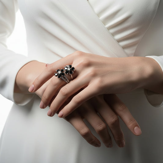 Silver ring with intricate design on a black hand against a dark background, featuring the brand 'Saheli'.