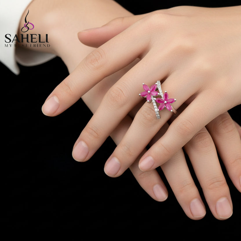 Floral ring with pink flowers on a black mannequin hand, brand 'SAHELI' visible.