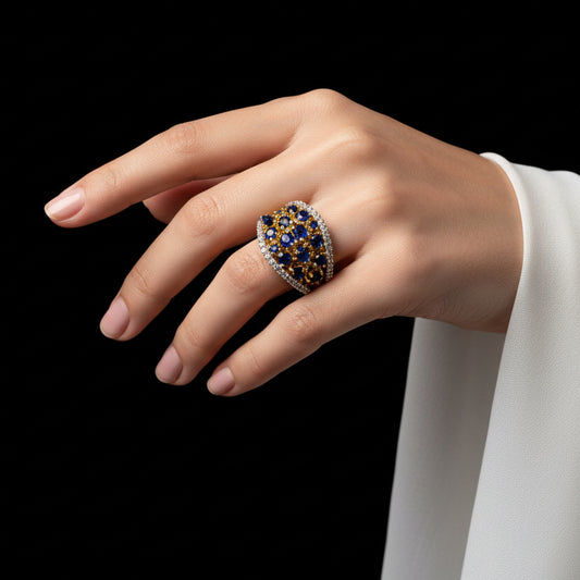 Gold ring with gemstones on a gray surface, with a label in the corner.