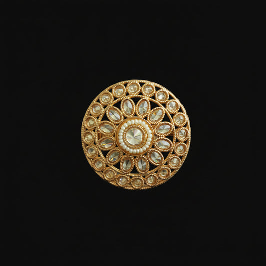Decorative gold button with gemstones on a dark background