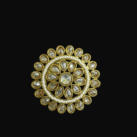 Decorative ring with gold and gemstone design on a dark background
