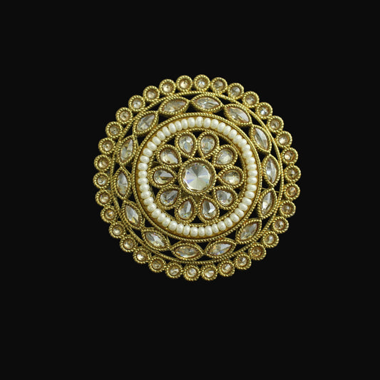 Decorative ring with gold and pearl design on a dark background