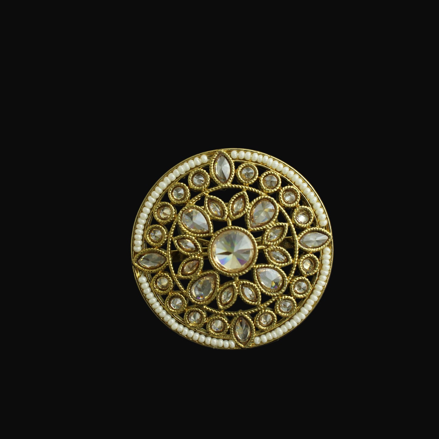 Decorative circular object with gold and gemstone design on a black background