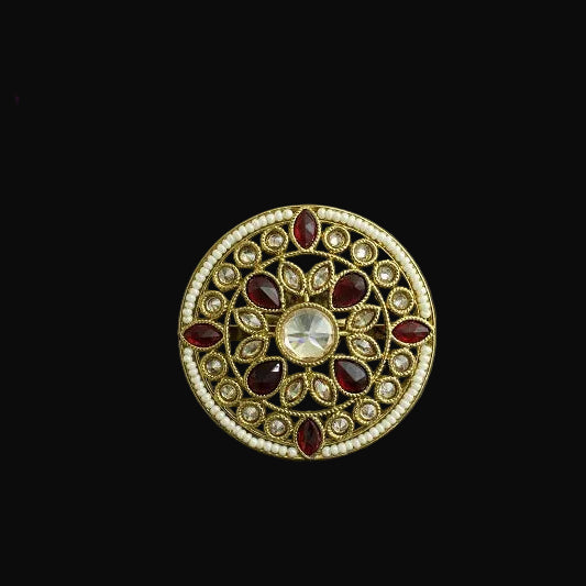 Decorative brooch with gemstones on a dark background, branded 'Saheli'.
