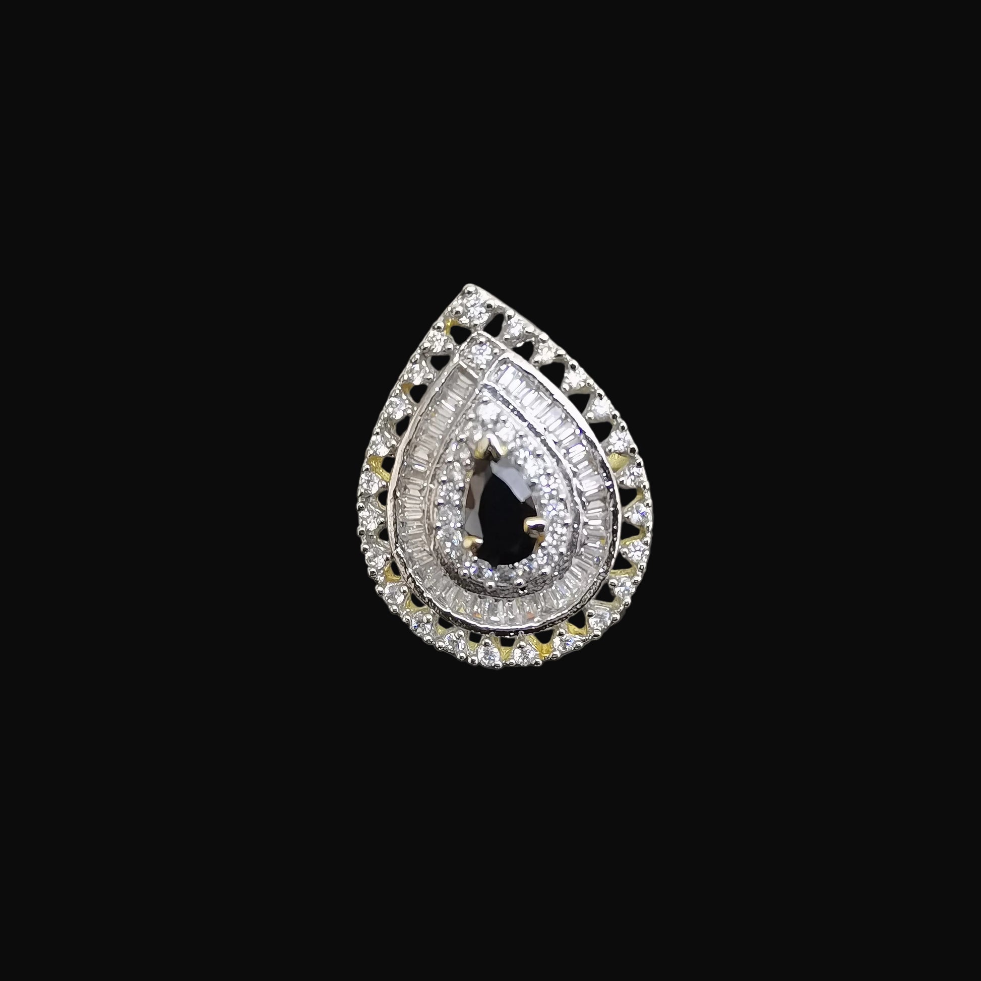 Teardrop-shaped diamond earring with black gemstone on a reflective surface, branded 'Saheli'.