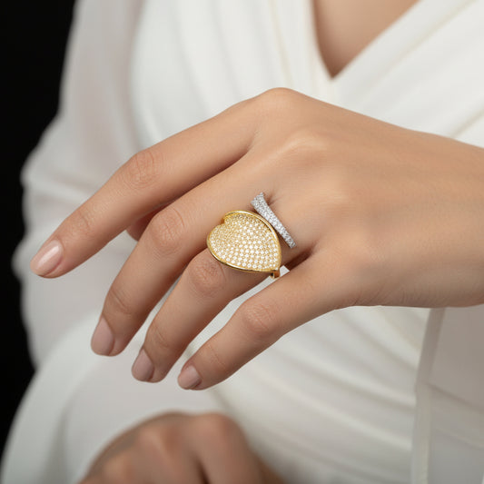 Gold and diamond ring on a gray background with 'Saheli' branding.