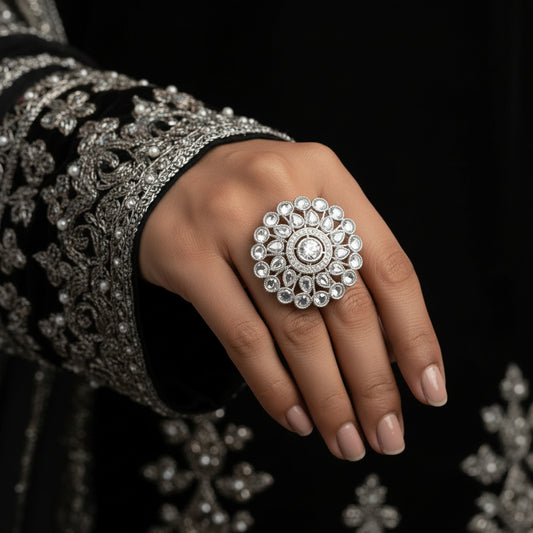 Silver ring with intricate design on a hand, brand 'Saheli' visible