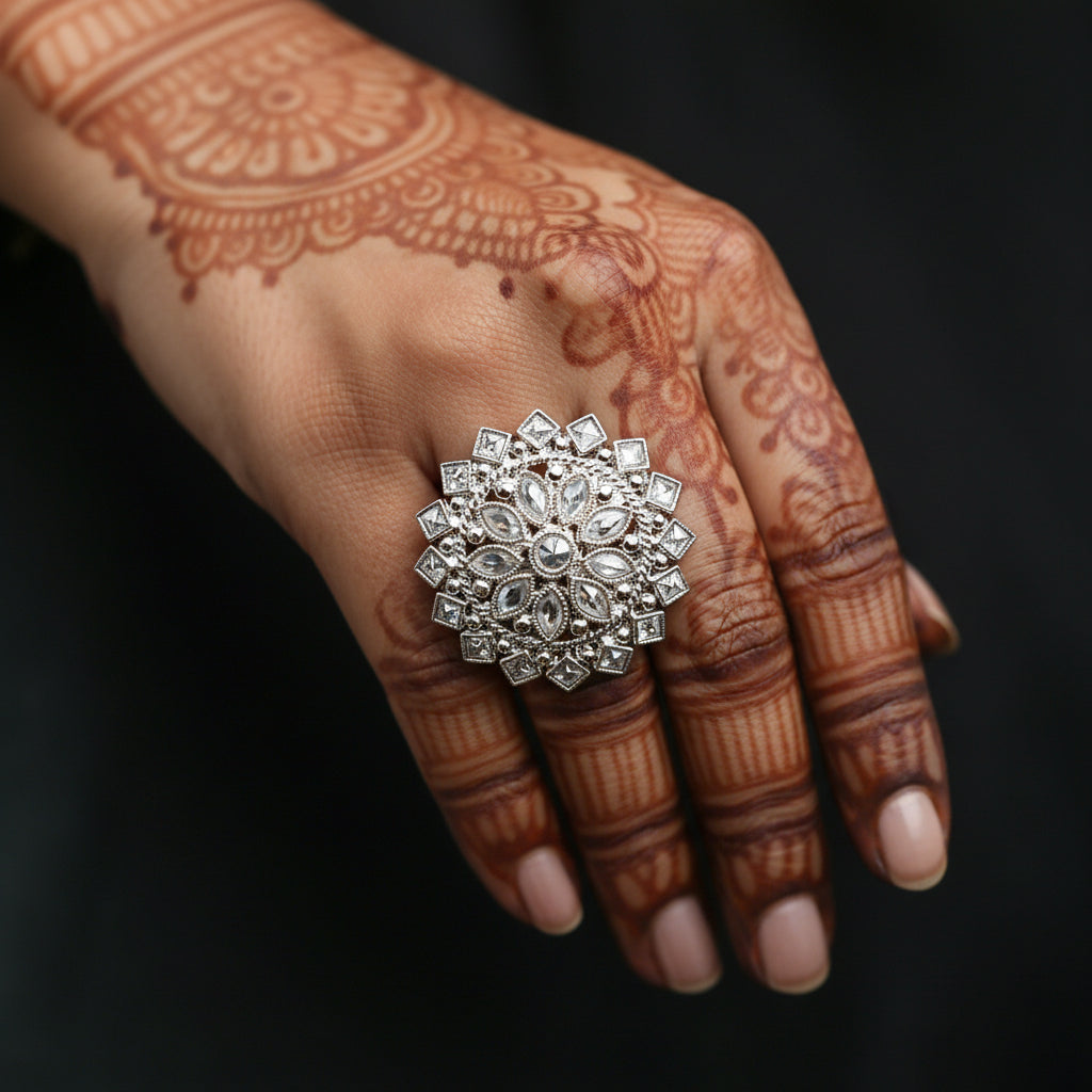A large, ornate silver ring with clear gemstones is displayed on a black velvet hand against a dark background. The brand logo 'SAHELL MY BEST FRIEND' is visible near the top center.