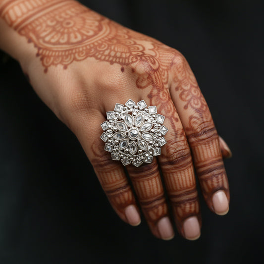 A large, ornate silver ring with clear gemstones is displayed on a black velvet hand against a dark background. The brand logo 'SAHELL MY BEST FRIEND' is visible near the top center.