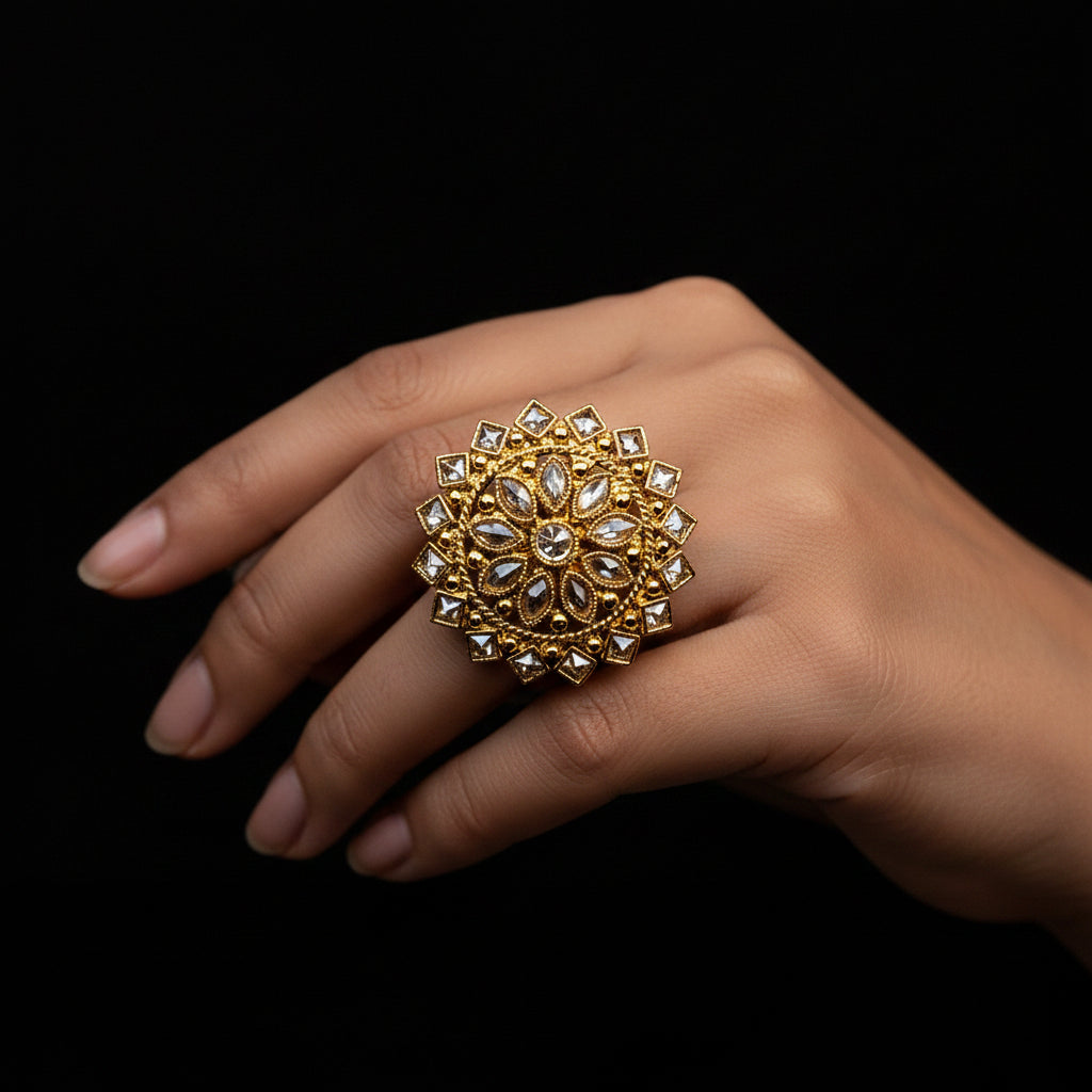 A large ornate gold ring with clear stones is displayed on a black velvet hand against a black background, with the text 'SAHELI MY BEST FRIEND' centered above the hand.