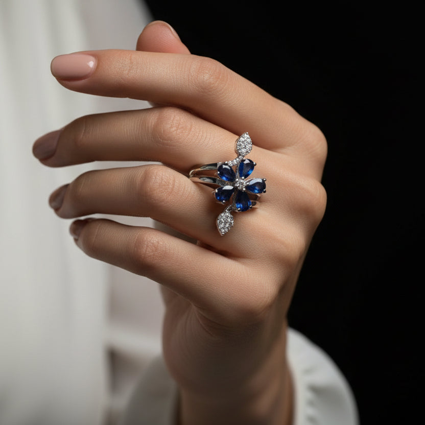 Silver ring with blue gemstones and a 'SAHELII' tag on a dark background