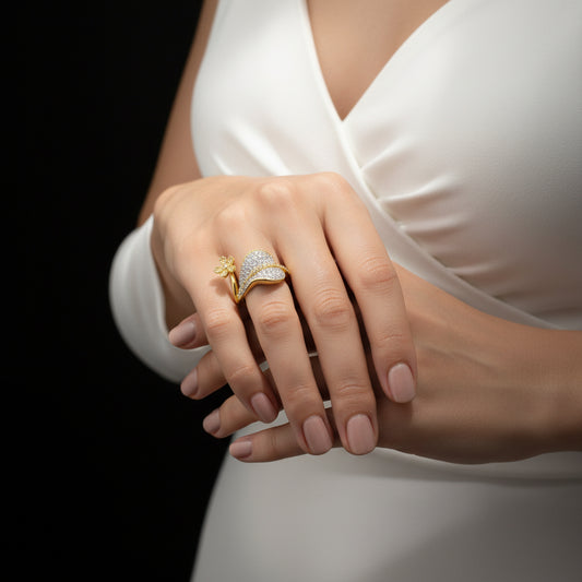 Gold ring with floral design on a gray background, featuring the brand 'Saheli'.