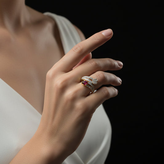 Gold and diamond ring with a red gemstone on a dark background, branded 'Saheli'.