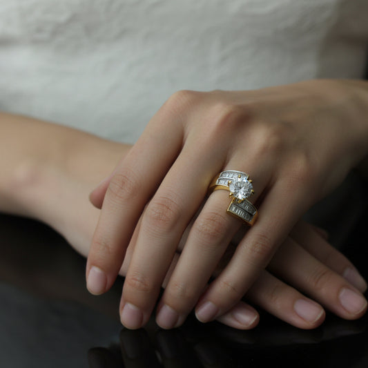 Gold ring with diamonds on a dark background, featuring the 'Saheli' brand.