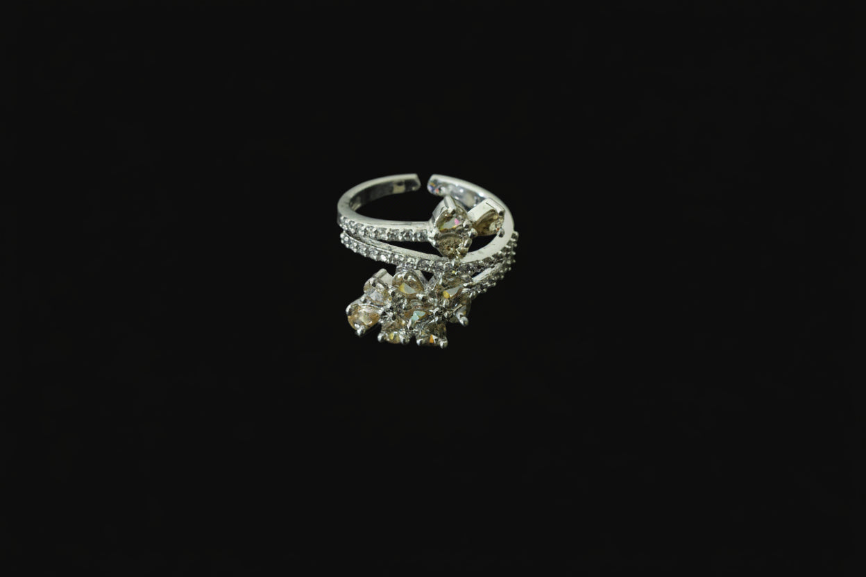 Silver ring with gemstones on a black background, featuring the 'Saheli' brand.