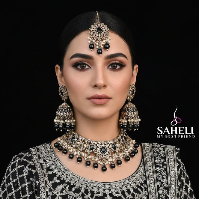 Jewelry set with necklace, earrings, and tikka on a black background with 'Saheli' brand logo.
