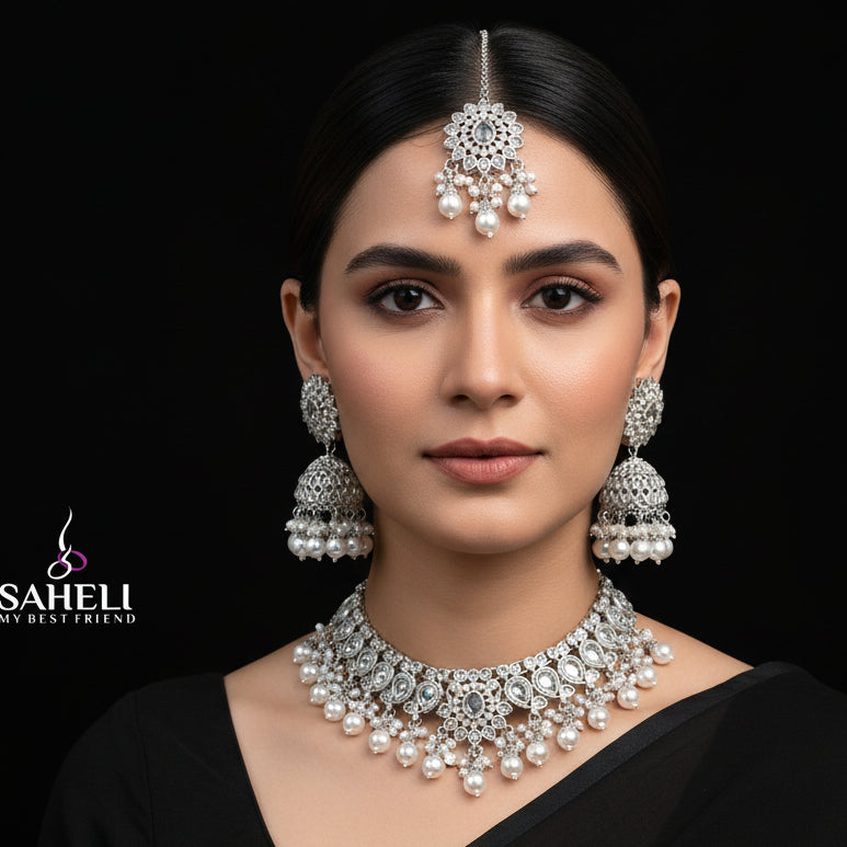 Silver jewelry set with necklace, earrings, and 'Saheli' brand logo on a black background