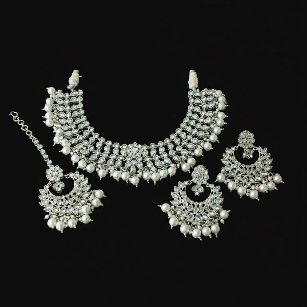 Silver necklace set with pearls on a dark background, featuring the brand 'Saheli'.