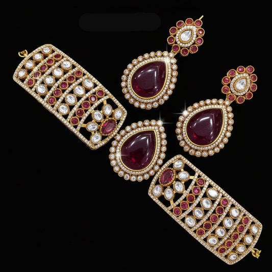 Jewelry set with maroon stones and gold accents on a white background
