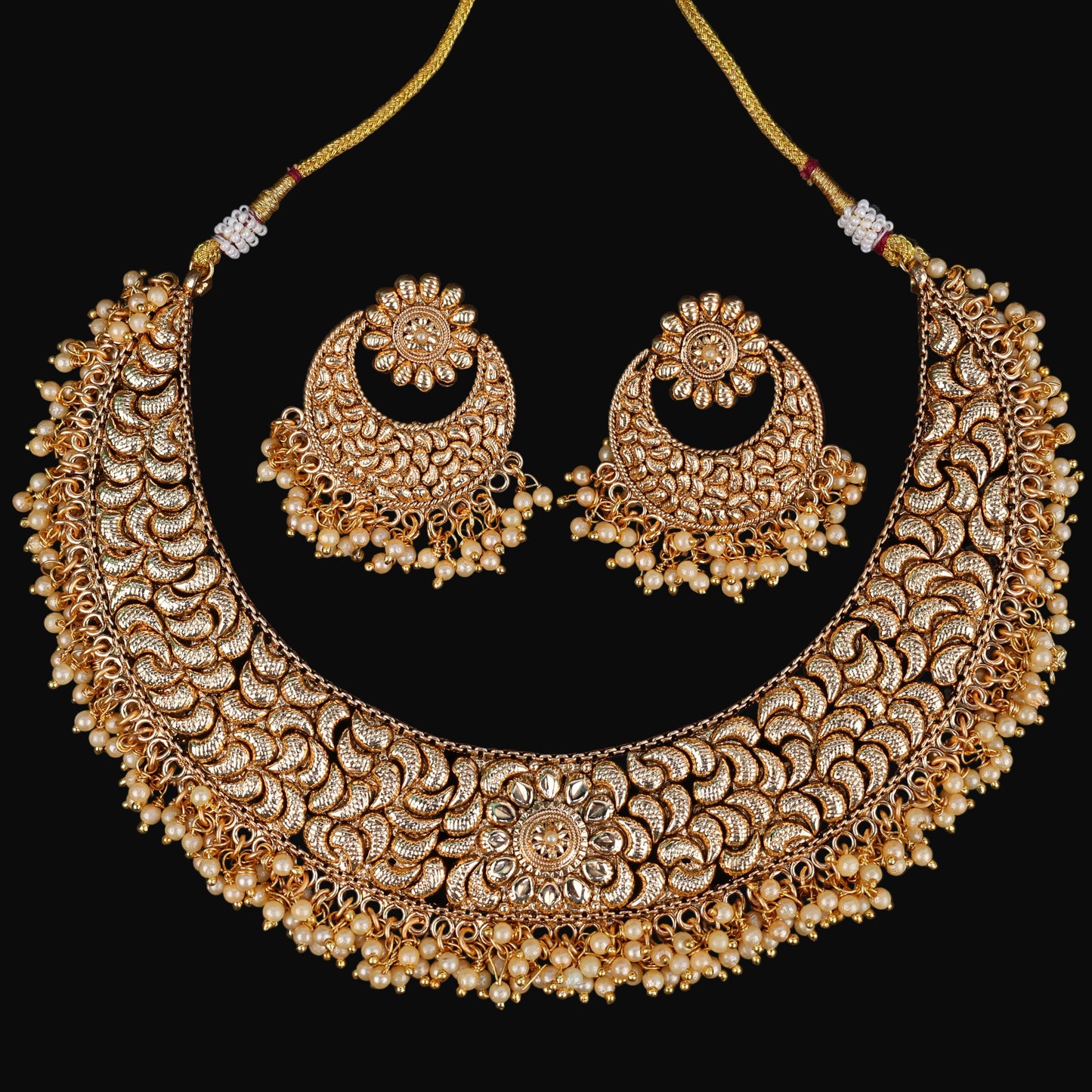 Gold necklace and earrings set with 'SAHELI' branding on a dark background