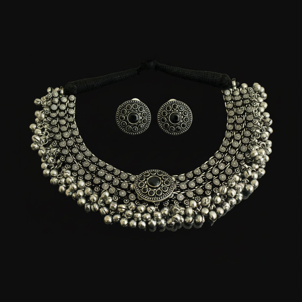 Silver necklace and earrings set on a dark background