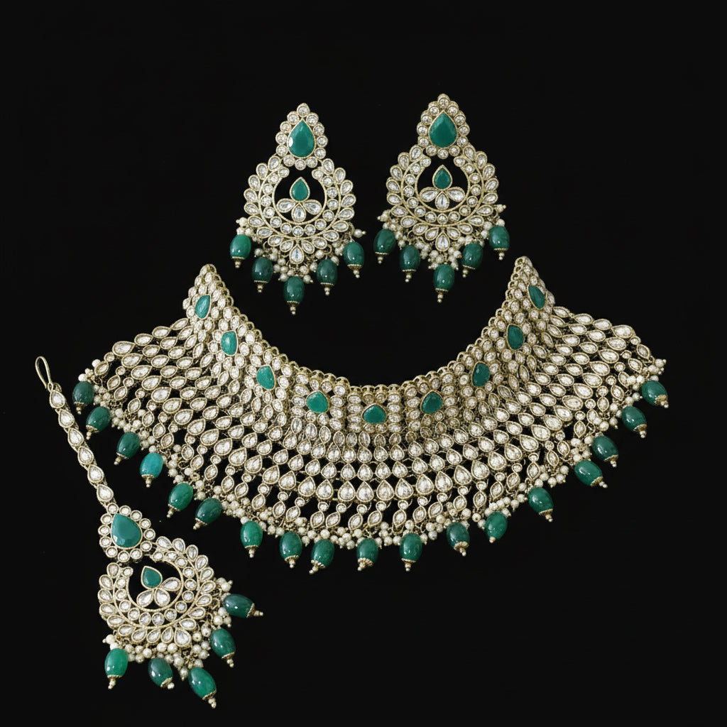 Ornate necklace set with green stones on a dark background, featuring the brand 'Saheli'.