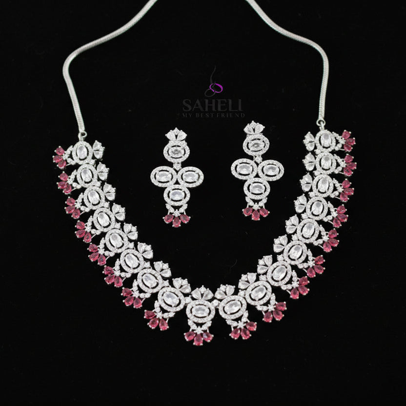 Jewelry set with necklace and earrings on a gray background, branded 'SAHELI'.