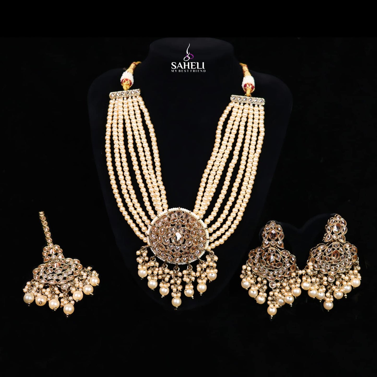 Pearl necklace and earrings set on a black background with 'Saheli' branding.