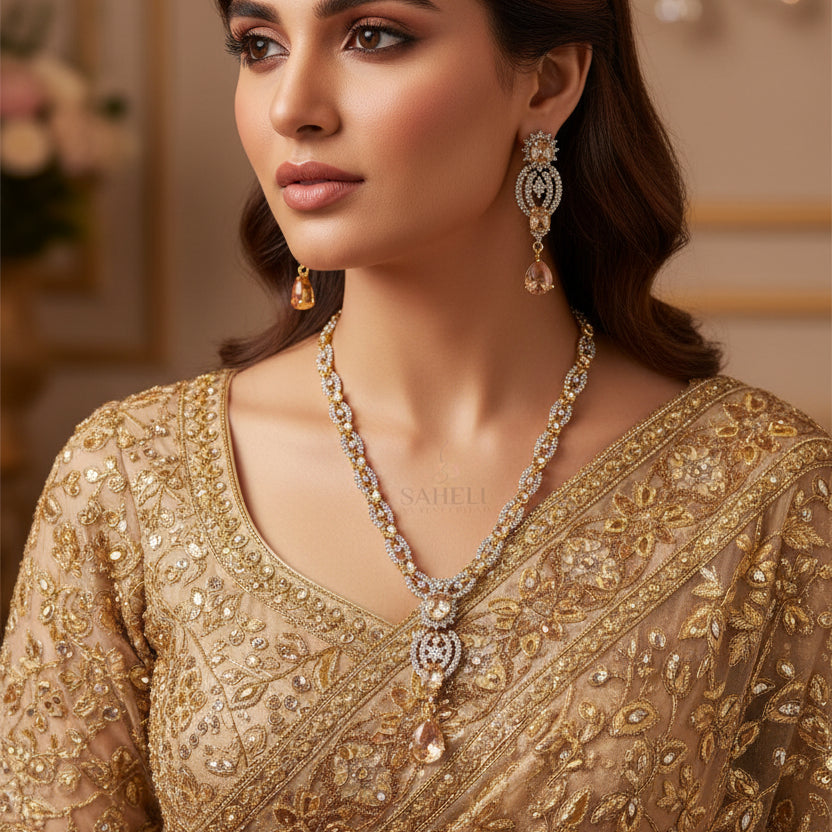 Jewelry set with necklace and earrings on a black background, featuring the brand 'Saheli'.