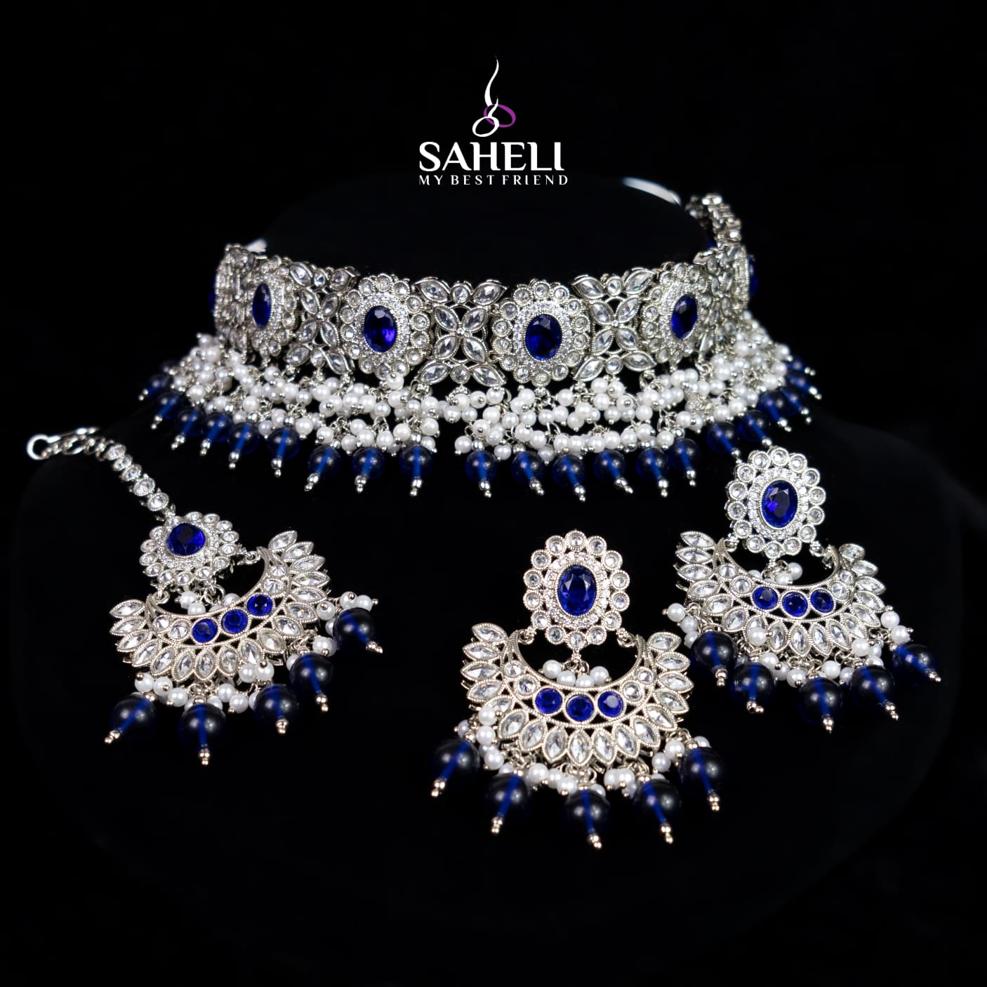 Jewelry set with necklace, earrings, and choker on a black background with 'Saheli' branding.