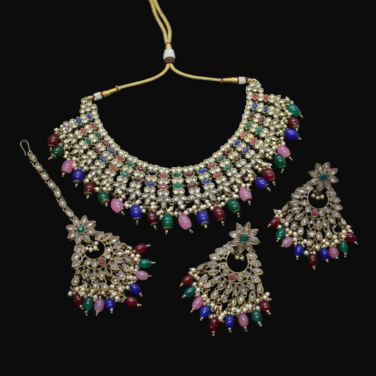 Ornate jewelry set with colorful gemstones on a dark background