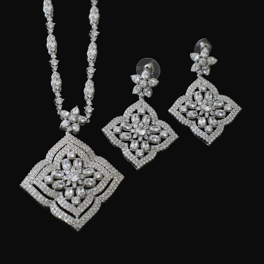 Silver necklace and earrings set on a black background